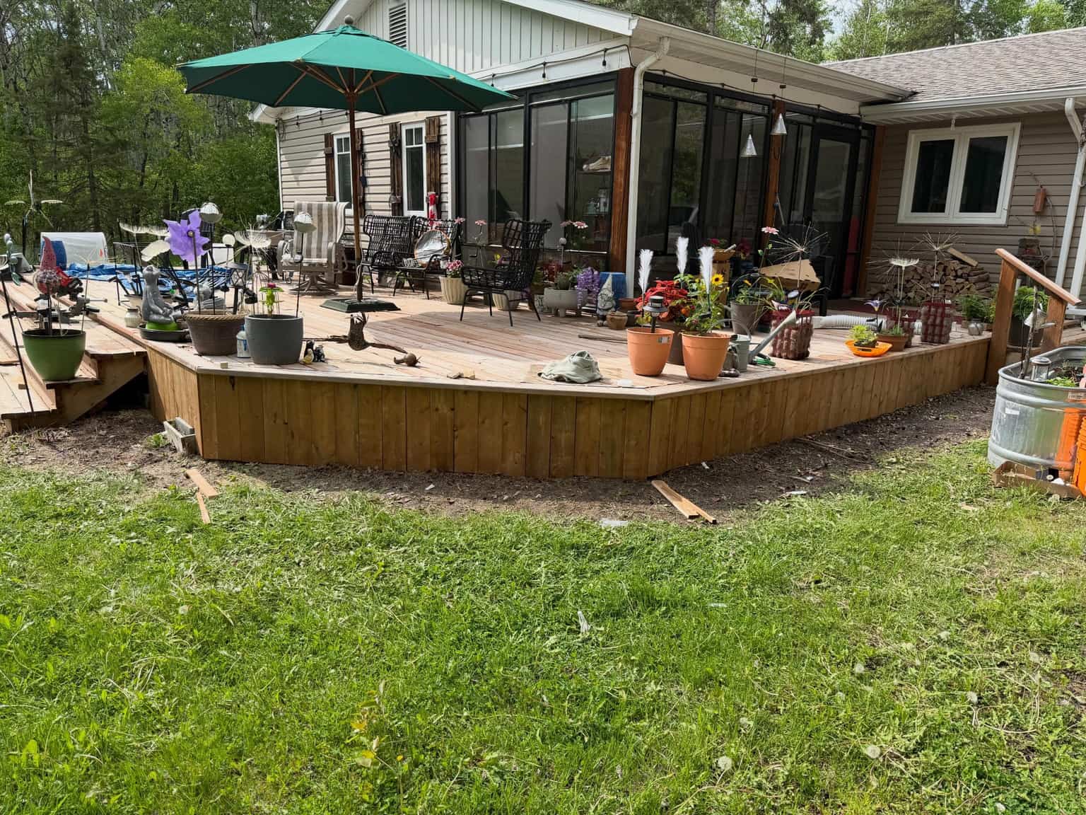 A rebuilt wrap-around cedar deck wrapping the back of a Manitoba home.