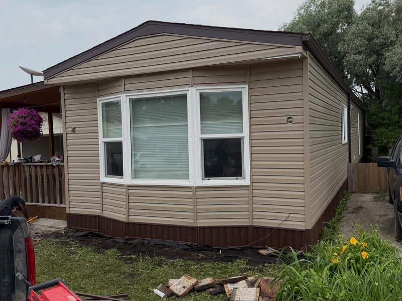 The same wall finished: new horizontal siding with wrapped corners, fresh fascia and skirting.